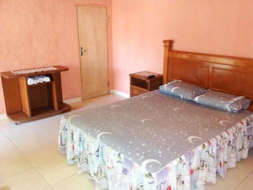 a bedroom with a bed and a table and a door at La Ponderosa in Asunción