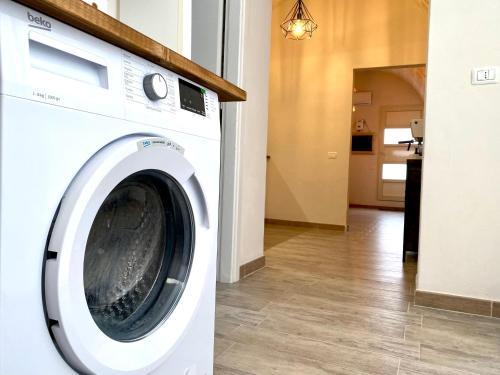 a white washing machine sitting in a laundry room at Il Pumo Rosa - Puglia Mia Apartments in Monopoli