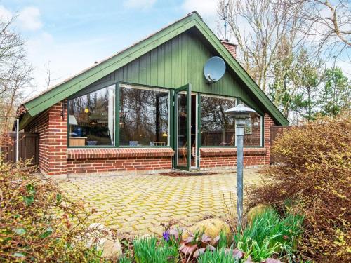 uma casa com um telhado verde e uma casa de tijolos em 4 person holiday home in Ulfborg em Ulfborg