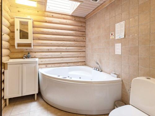 NordostにあるHoliday Home Kulmulevejの木製の壁のバスルーム(白いバスタブ付)
