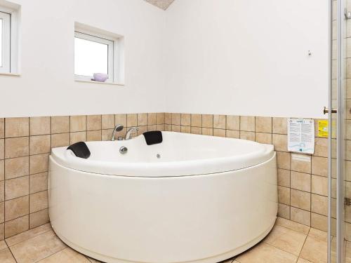 een badkamer met een wit bad en een raam bij 8 person holiday home in Brovst in Brovst