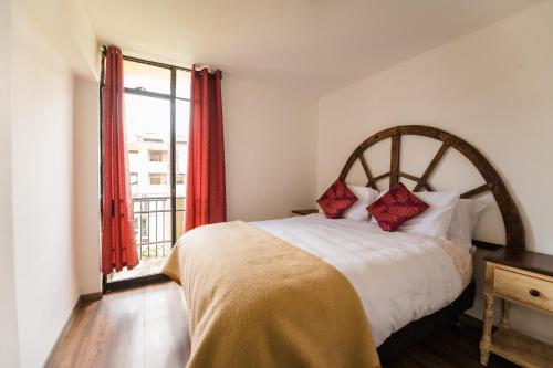 a bedroom with a bed with a large window at Cozy home - La casa de Luna in Cusco