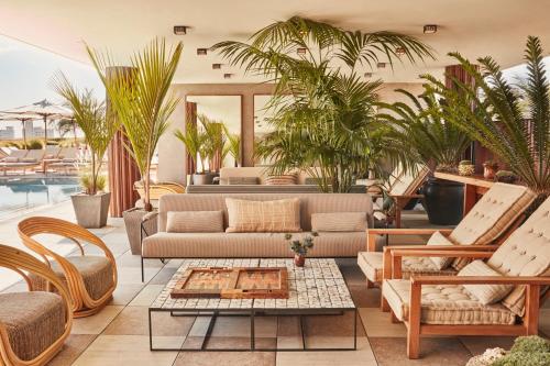 a living room with a couch and chairs and a table at Santa Monica Proper Hotel, a Member of Design Hotels in Los Angeles