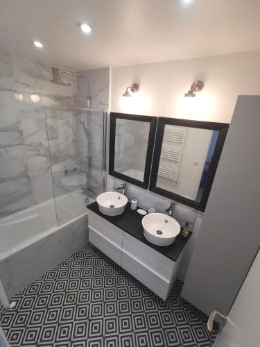La salle de bains est pourvue de 2 lavabos, d'une douche et d'une baignoire. dans l'établissement Ker Romain - Sea View - 3 bedrooms Appt, à Saint-Malo