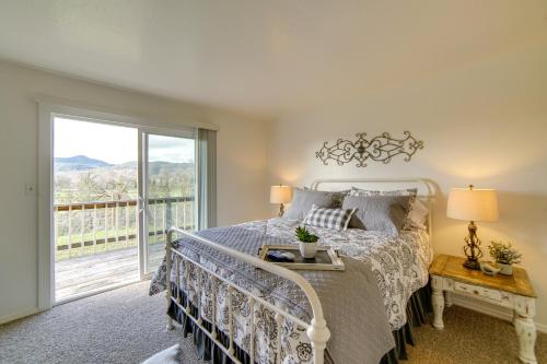 ein Schlafzimmer mit einem Bett und einem großen Fenster in der Unterkunft 30-Acre Witter Springs Ranch with Barn and Views! in Upper Lake