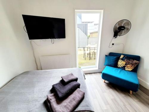 a bedroom with a bed and a chair and a television at One bedroom apartment with a terrace in Angel (Islington)! in London