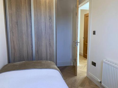 1 dormitorio con 1 cama y puerta abierta en Modern Space 20 minutes from Dublin Airport, en Dunboyne