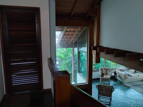 een kamer met een trap en een glazen deur bij Casa à 250m praia Martim de Sá, quiosques, restaurantes e lazer in Caraguatatuba