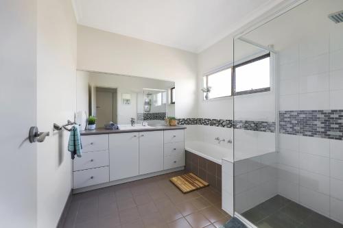 a white bathroom with a shower and a sink at Hillside - Family Orientated Holiday Home in Warrnambool