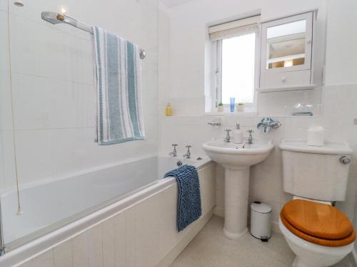 a white bathroom with a toilet and a sink at Home-Straight in Stratford-upon-Avon