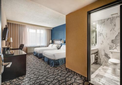 ein Hotelzimmer mit einem Bett und einem Bad in der Unterkunft Empire Suites in Montreal