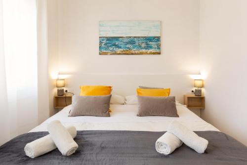 um quarto com uma cama grande e 2 almofadas em Confort apartamentos en playa, 3 DRM em Barcelona