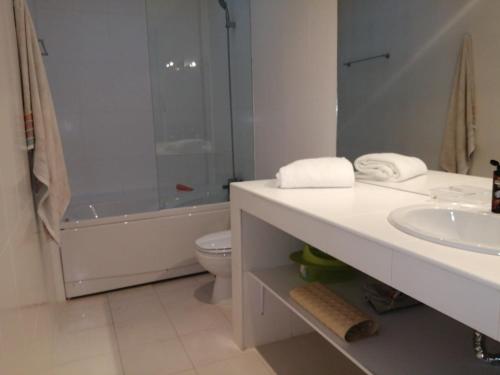a bathroom with a sink and a toilet and a shower at White beach luxury vila in Sagres