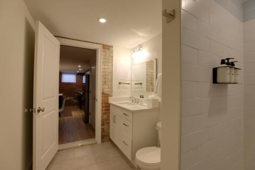 a white bathroom with a toilet and a sink at Mint House Detroit - Brush Park in Detroit