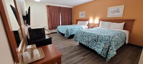 a hotel room with two beds and a television at Harvey's Motel SDSU La Mesa San Diego in San Diego