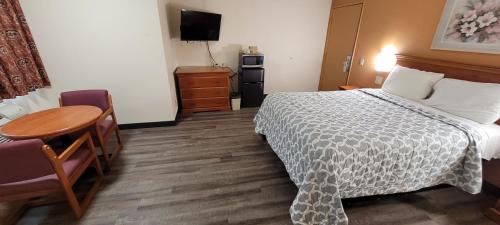 a hotel room with a bed and a table at Harvey's Motel SDSU La Mesa San Diego in San Diego