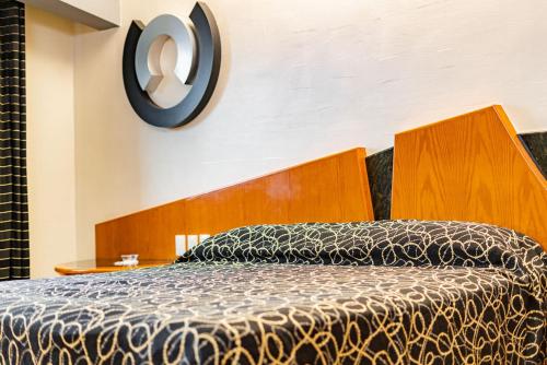 een bed met een houten hoofdeinde in een kamer bij Hotel Pasadena CDMX in Mexico-Stad