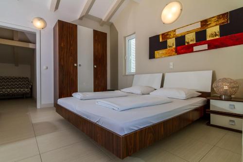 a bedroom with a large bed with white sheets at Apartments Marco Polo in Rab