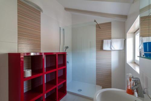 a bathroom with a red cabinet next to a shower at Apartments Marco Polo in Rab