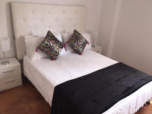 een slaapkamer met een wit bed met 2 kussens bij Playa Granada Golf in Motril