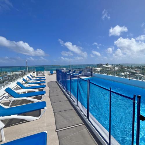 聖安德烈斯的住宿－Azure Lofts & Pool，游泳池旁的一排躺椅