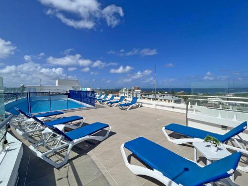 una fila de tumbonas y una piscina en la azotea en Azure Lofts & Pool en San Andrés