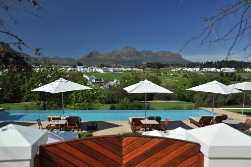 a pool with tables and chairs and umbrellas at De Zalze Lodge in Stellenbosch