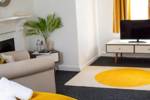 a living room with a couch and a television at SHM Stays HS2 workers Great for long term stays & Short Stays, 15 min drive to City Centre & Airport 2 min walk to Shops and Train Station in Birmingham