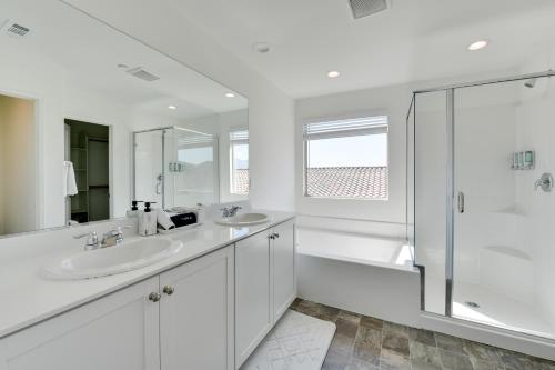 - une salle de bains blanche avec deux lavabos et une douche dans l'établissement Coachella Vacation Rental Near Empire Polo Field!, à Coachella