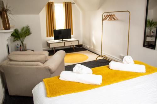 a room with a bed and a couch and a television at SHM Stays HS2 workers Great for long term stays & Short Stays, 15 min drive to City Centre & Airport 2 min walk to Shops and Train Station in Birmingham