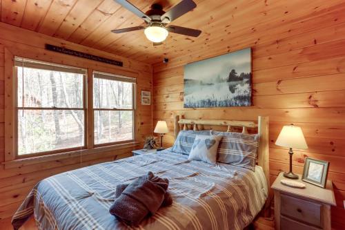 ein Schlafzimmer mit einem Bett in einer Blockhütte in der Unterkunft Blue Ridge Cozy Cabin in the Woods with Hot Tub! in Blue Ridge