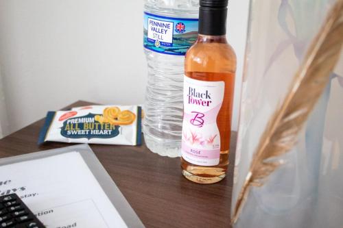 a bottle of wine sitting on a desk next to a computer at SHM Stays HS2 workers Great for long term stays & Short Stays, 15 min drive to City Centre & Airport 2 min walk to Shops and Train Station in Birmingham
