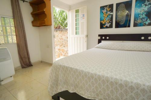 Un dormitorio con una cama grande y una ventana en Donde Ruka Hostal, en Santa Marta