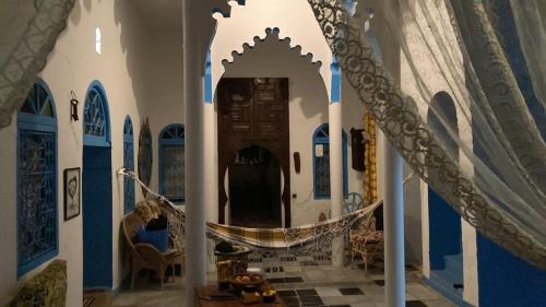 a hallway of a house with a hammock in it at Riad mama Aicha in Asilah
