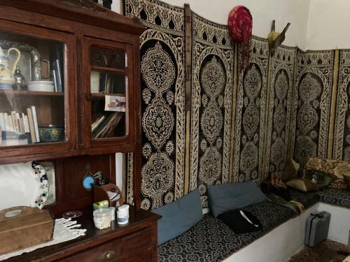 una camera con una parete in legno, un divano e un armadio di Riad mama Aicha a Asilah