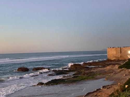 uma vista para o oceano a partir de uma praia em Riad mama Aicha em Asilah