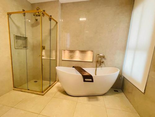a bathroom with a tub and a glass shower at Pousada Maracabana Spa in Porto De Galinhas