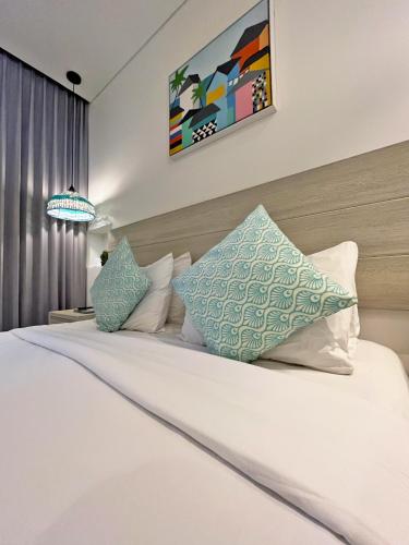 a bedroom with a bed with white sheets and pillows at Azure Lofts & Pool in San Andrés