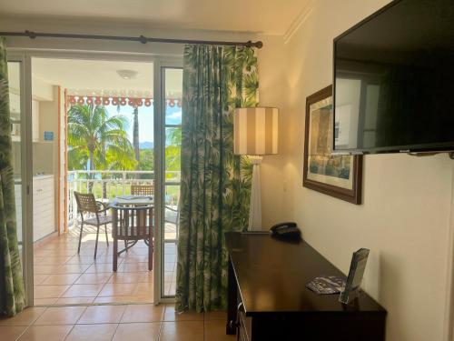 d'un salon avec une porte coulissante en verre s'ouvrant sur une terrasse. dans l'établissement Appart avec piscine et vue mer - TIC, à Sainte-Luce