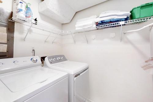 a white laundry room with a washer and dryer at Captains Court 1004 in Fernandina Beach