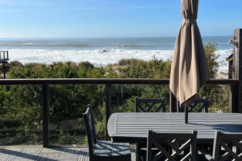 a table and an umbrella on a balcony with the ocean at Idyllic Ocean-View Oasis in Watsonville