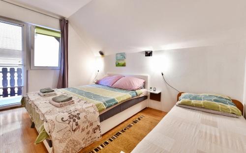 een slaapkamer met 2 bedden en een raam bij Apartments with a parking space Saborsko, Plitvice - 20975 in Saborsko