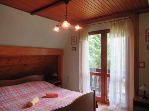 1 dormitorio con cama y ventana grande en Family friendly house with a parking space Kuzelj, Gorski kotar - 20980, en Kuželj