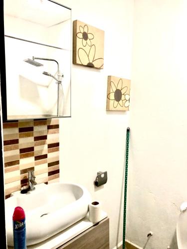 a bathroom with a sink and a mirror at Yazmin Studio Residence in Lamin