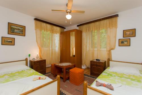 um quarto com 2 camas e uma ventoinha de tecto em Apartments by the sea Kastel Kambelovac, Kastela - 20942 em Kaštela