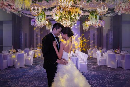 a bride and groom standing in front of a banquet hall at Clark Marriott Hotel in Clark