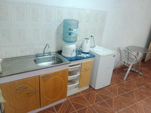 a small kitchen with a sink and a refrigerator at Habitación cerca aeropuerto in Calama