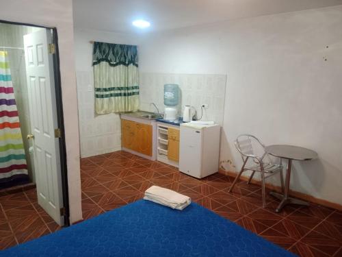 a small kitchen with a table and a blue floor at Habitación cerca aeropuerto in Calama