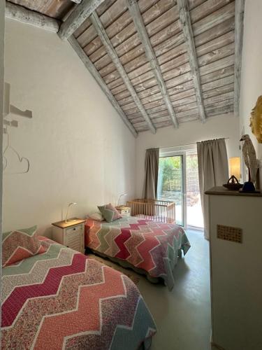 1 dormitorio con 2 camas y ventana en Casas na Lagoa - Carvalhal, en Carvalhal