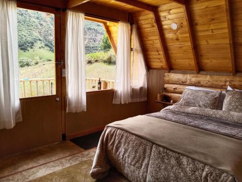 a bedroom with a bed and a large window at Cabaña en La Calera Zihita in La Calera